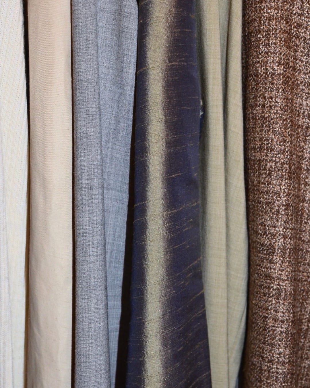Shelved rolls of nylon, canvas, vinyl, and leather stocked at Christian Workshop.
